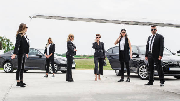 Professional team of female and male bodyguards protect famous VIP celebrity public person. Close security protection. Police agent in civilian black suit